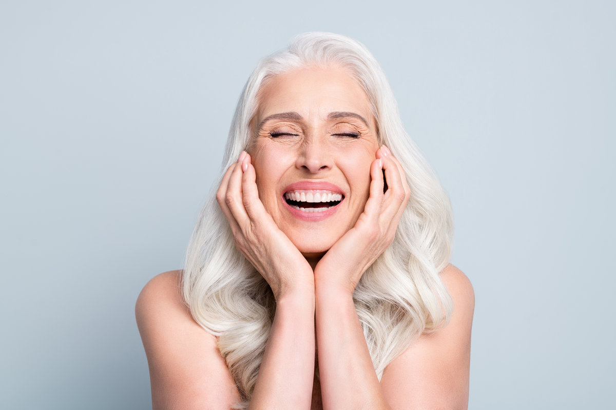 Close-up portrait of her she nice attractive excited cheerful grey-haired elderly lady touching cheeks laughing isolated gray pastel color background.
