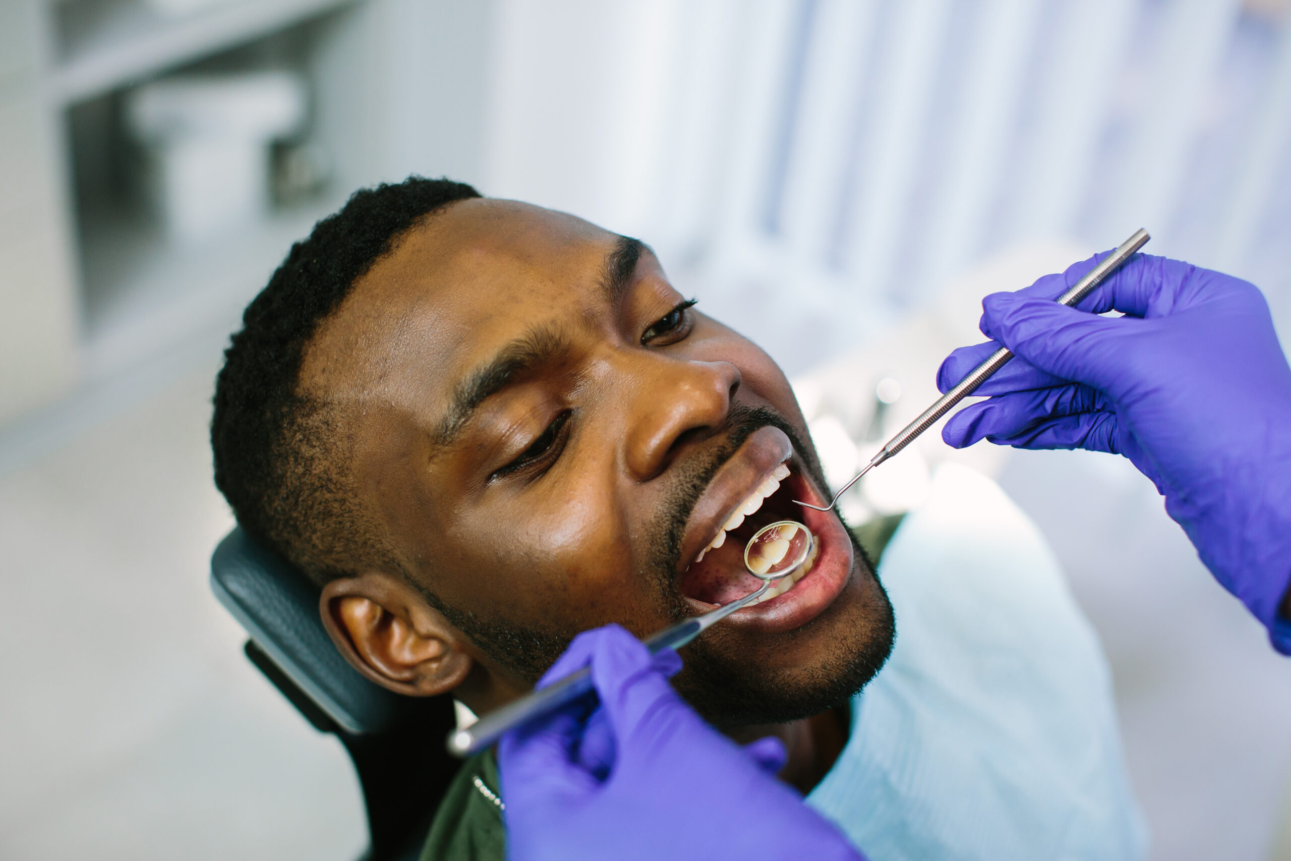 African male patient getting dental treatment in dental clinic